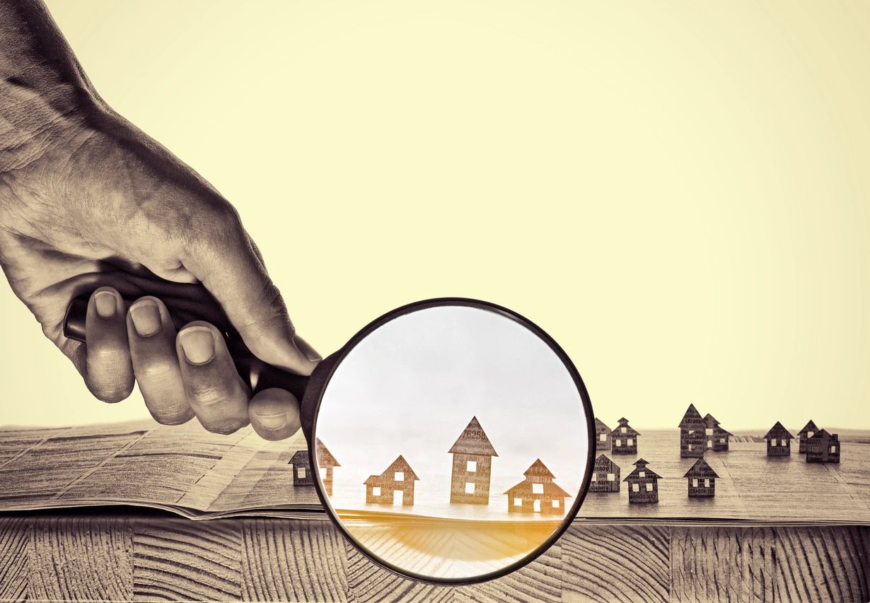 Magnifying glass over houses real estate inspection
